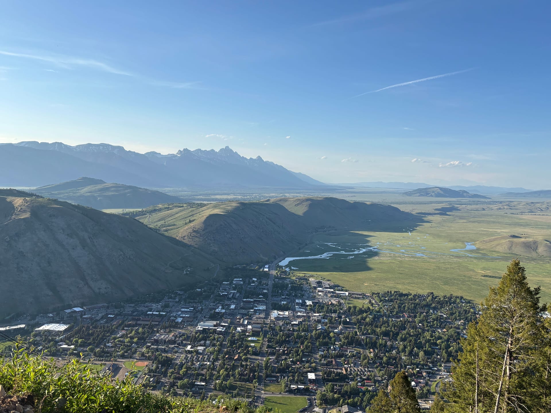 The town of Jackson nestled below the Teton Range in a green summer valley