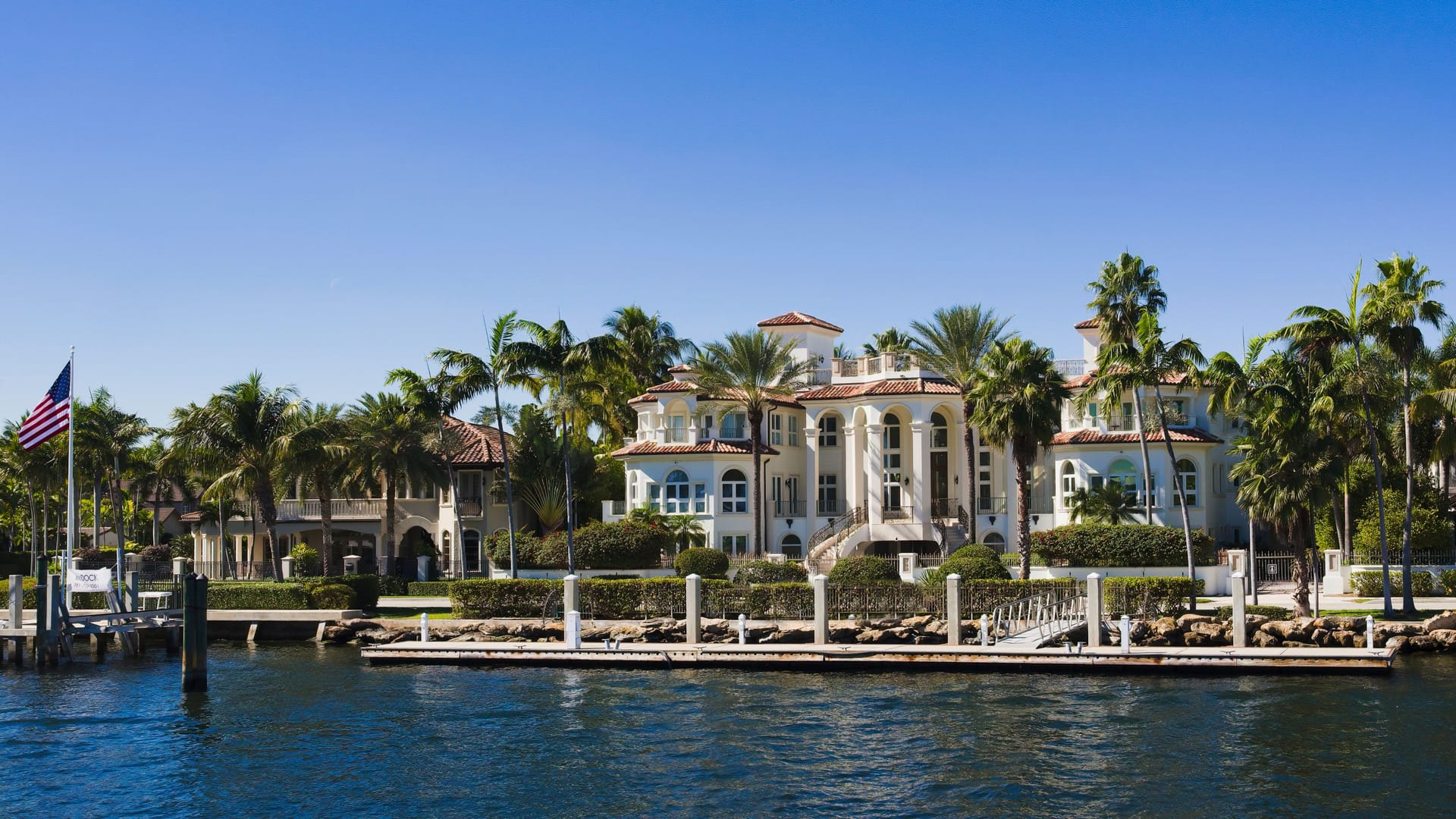 A waterfront Palm Beach estate lined with palm trees and a private dock