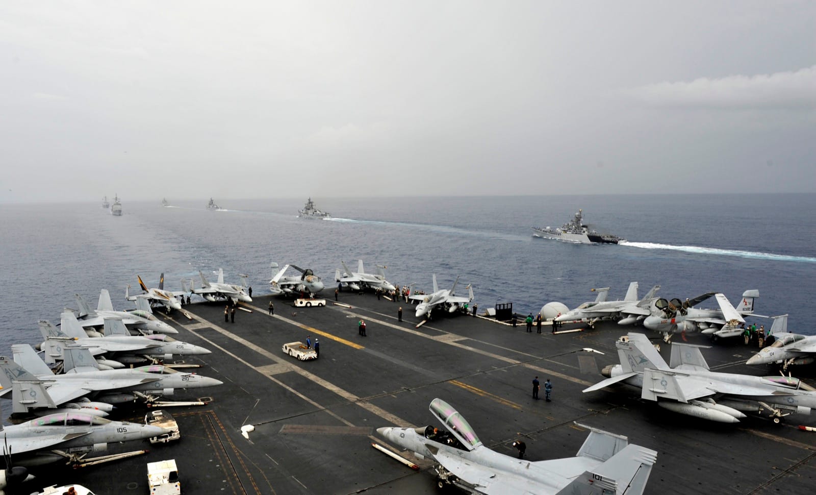 Aircraft packed at maximum density on a US Navy carrier flight deck, each scored against a reference jet by spot factor